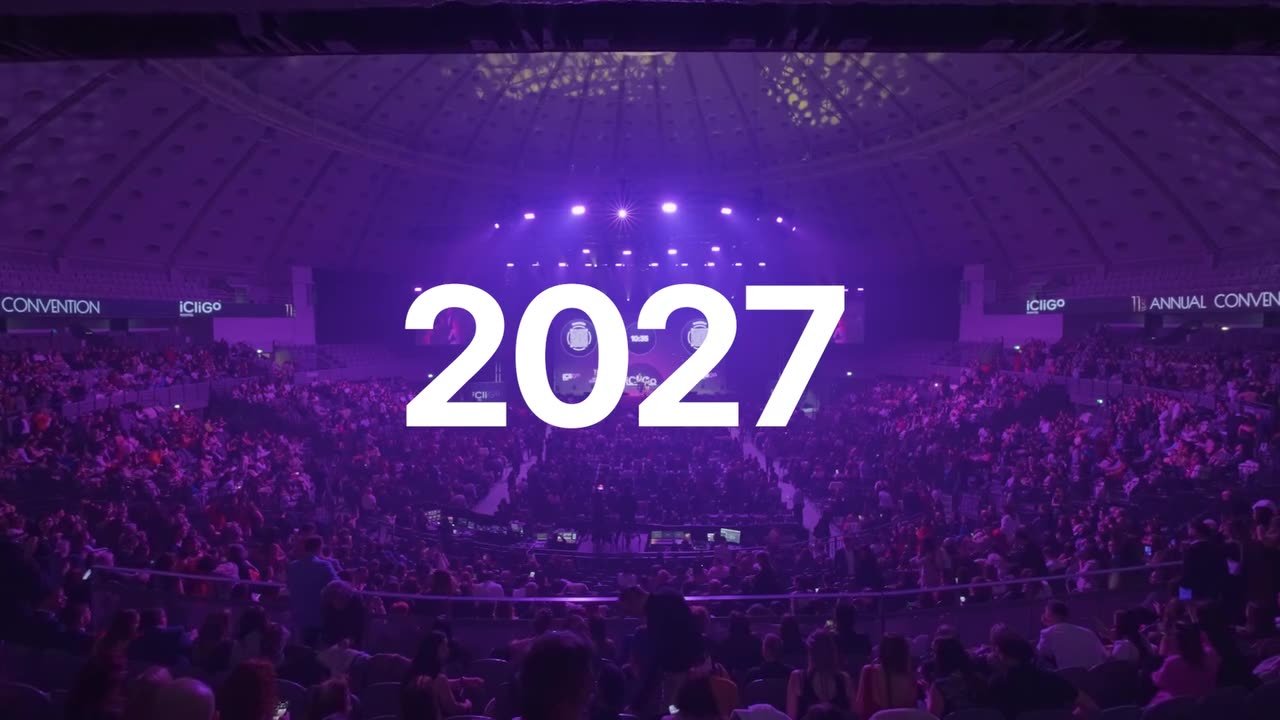 Plateia da Convenção Anual iCliGo com o palco iluminado a roxo